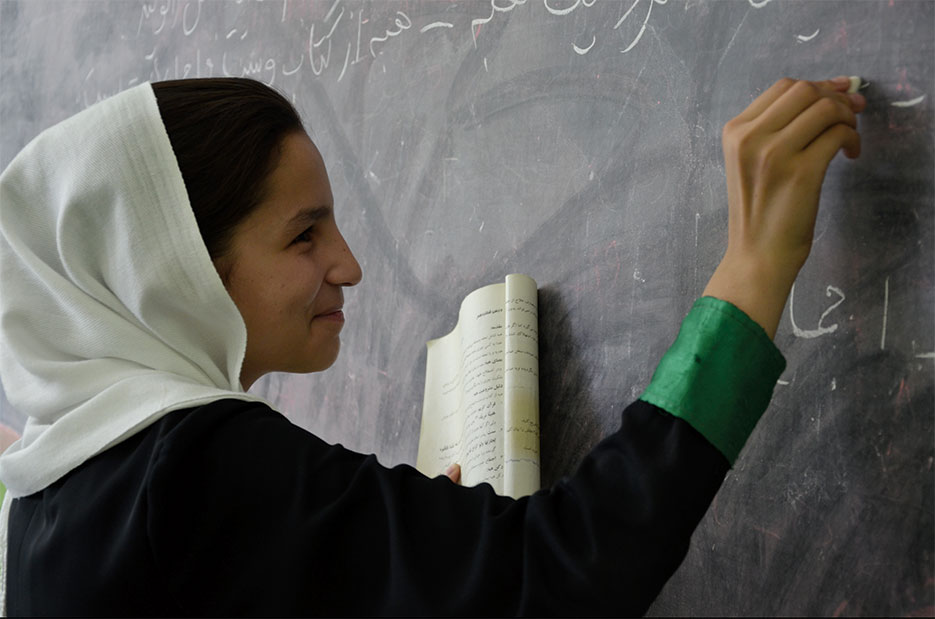 Student writes on chalkboard during English class at girls’ school in Kabul, Afghanistan, June 2011 (DOD/Catherine Threat)