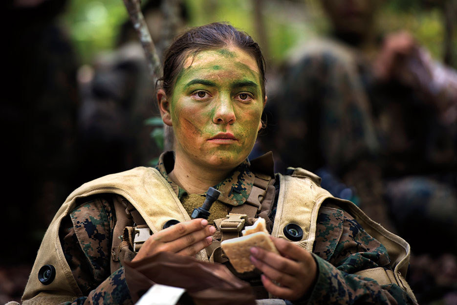 Private First Class Julia Carroll, one of the first three women to graduate from Infantry Training Battalion, eats small meal after 6-hour patrol near Camp Geiger, NC, October 2013 (U.S. Marine Corps/Tyler L. Main)