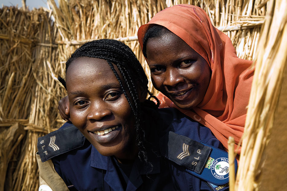 Hawa Mamoh (left), a Sierra Leonean officer with African Union–United Nations Hybrid Operation in Darfur, with Zara Adam, one of the displaced at Zam Zam internally displaced persons camp near El Fasher, North Darfur, Sudan (United Nations/Albert González Farran)